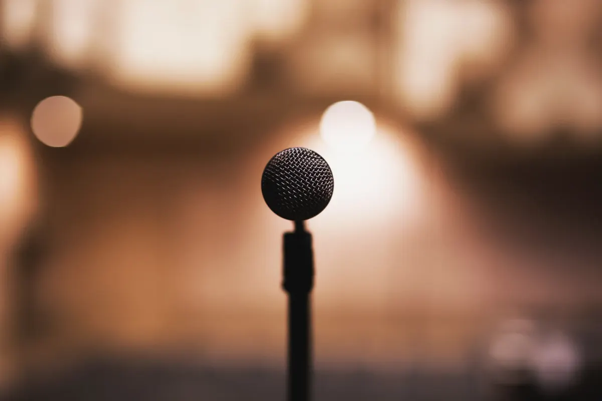 A microphone on a stand against an out-of-focus indoor background