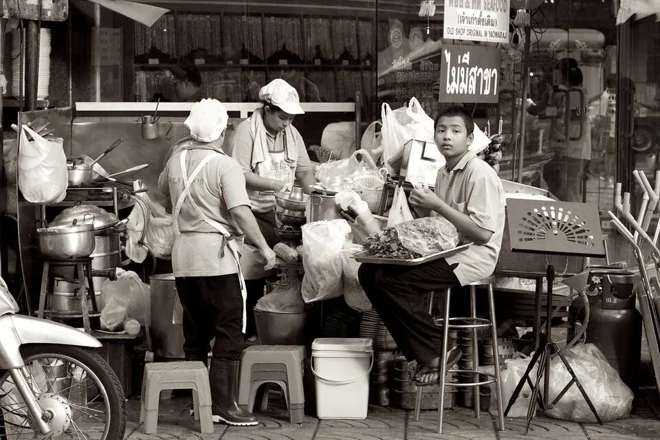 People beside produce stalls in a black-and-white market photograph