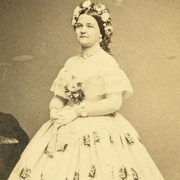 Mary Lincoln wearing a light-colored formal gown and floral headdress