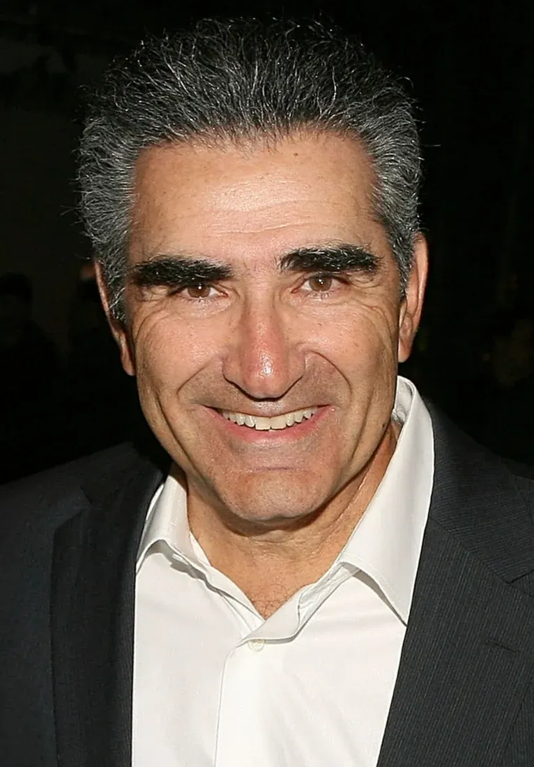 Eugene Levy in a dark jacket and an open-collar white shirt