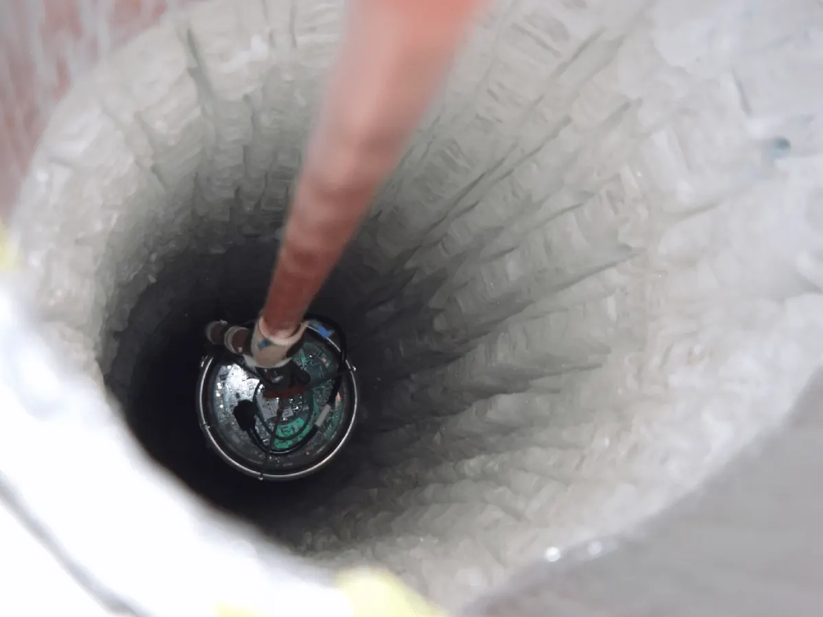An IceCube optical detector being lowered into a hole drilled through Antarctic ice