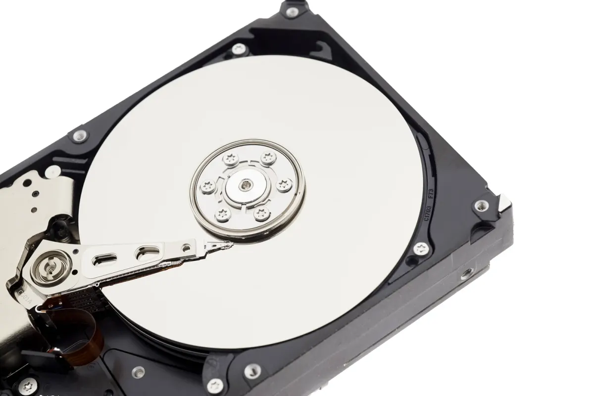 An opened hard drive showing its circular platter and read-write arm