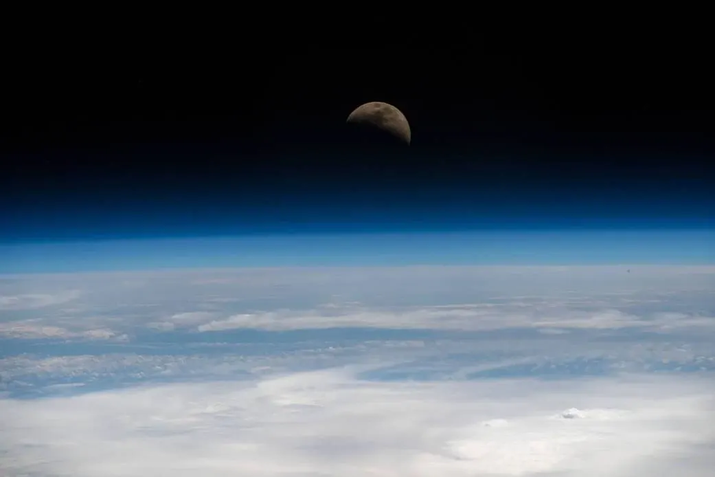 NASA photograph of a quarter Moon above Earth's horizon on April 11, 2019
