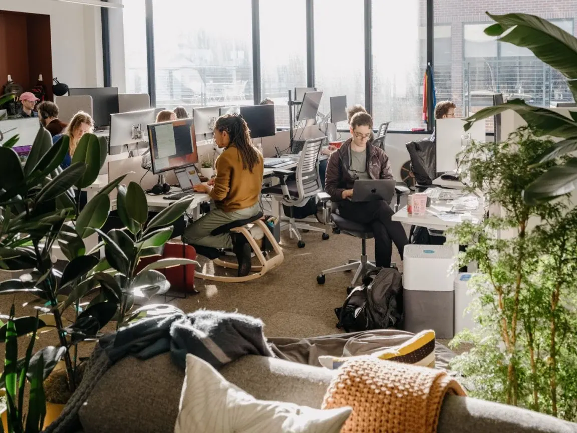 People working at desks in Anthropic's plant-filled office