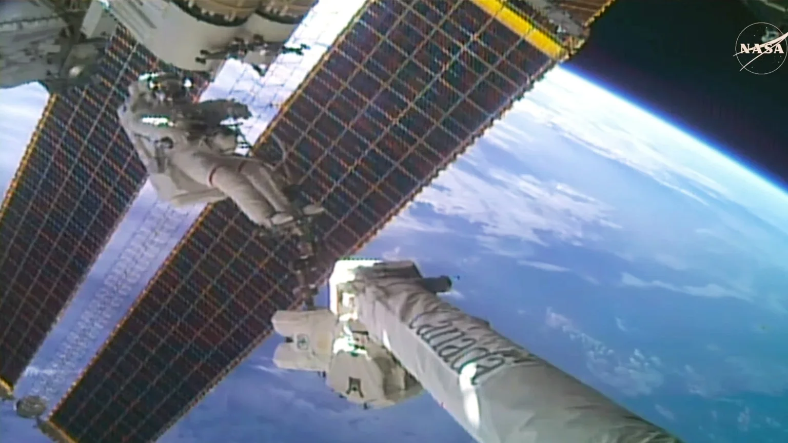 Astronaut Anil Menon on Canadarm2 beside a roll-out solar array during the October 29, 2026 spacewalk