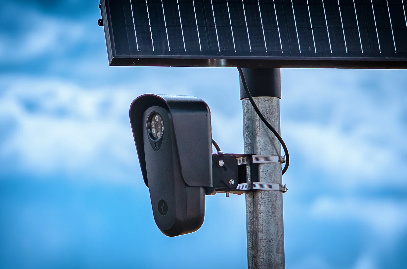 Flock Safety camera attached to a metal pole beneath a solar panel.