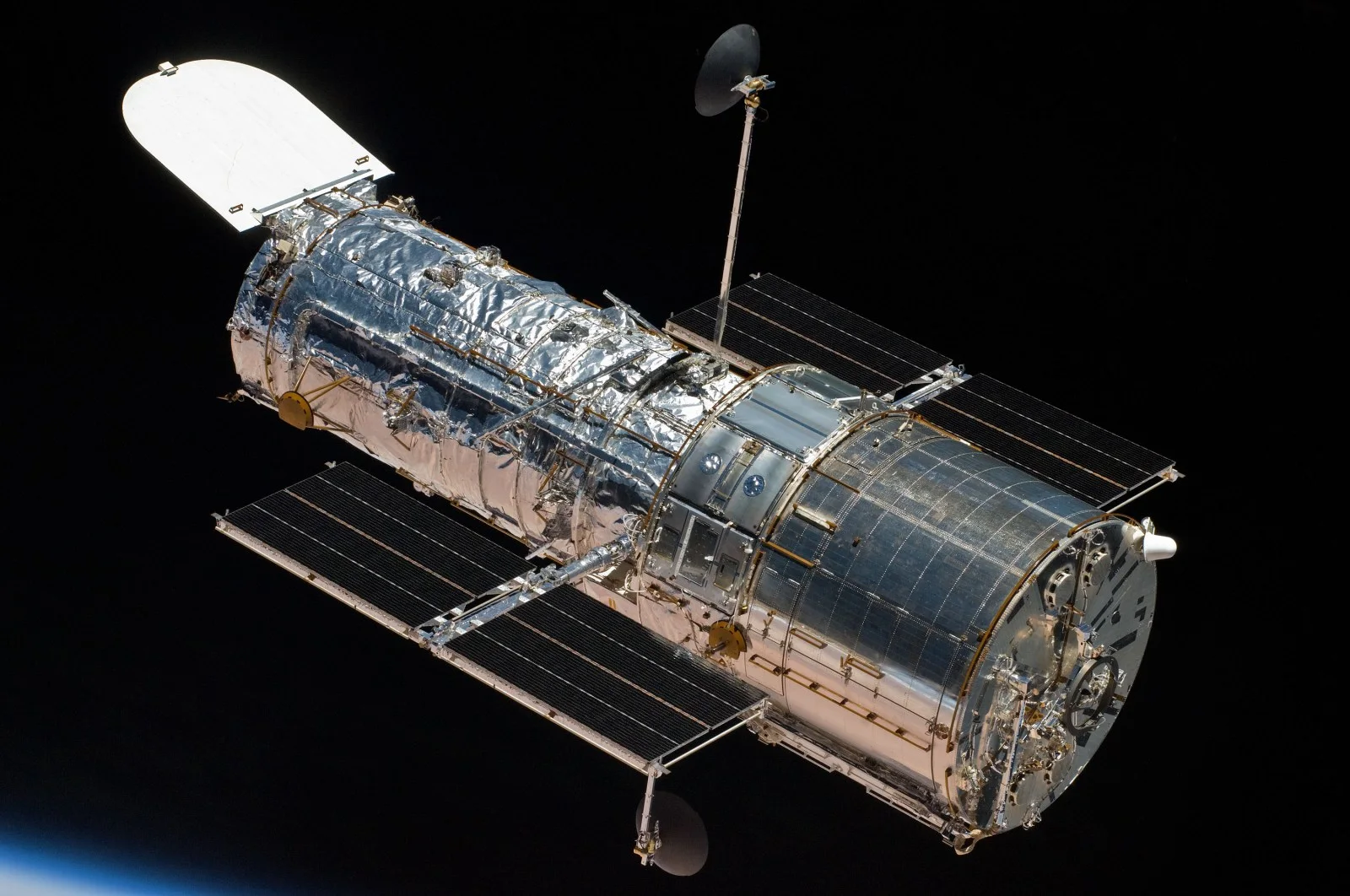 Close view of the Hubble Space Telescope with its solar panels extended against the black of space