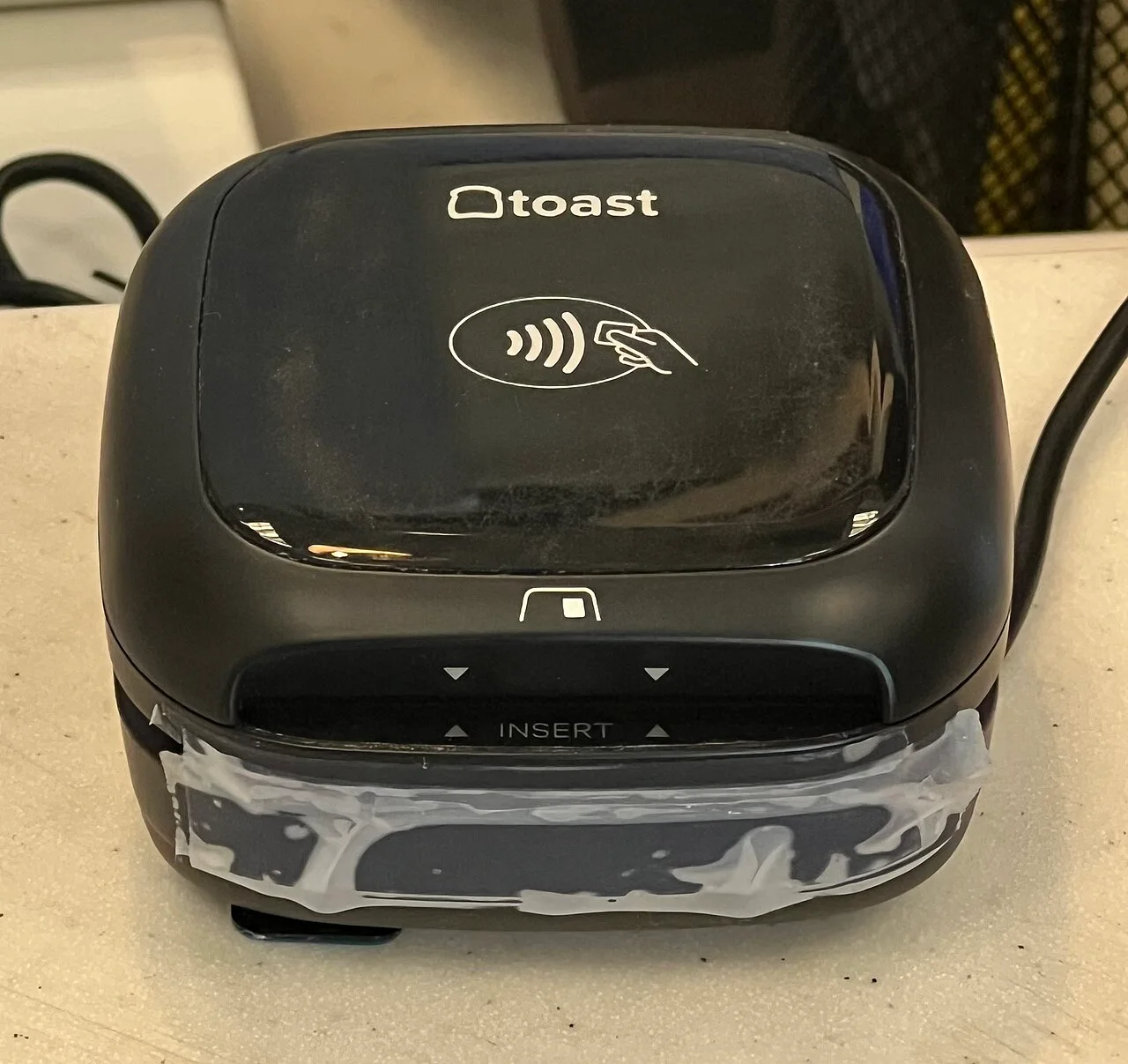 Toast Tap contactless card terminal with tap and chip-card symbols