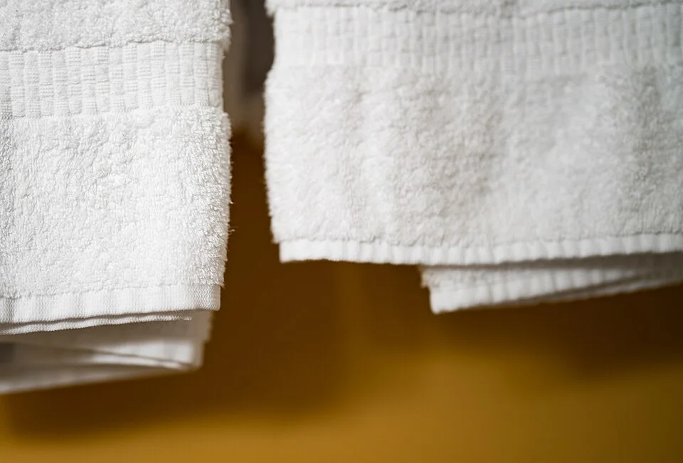 White towels hanging in a hotel room.