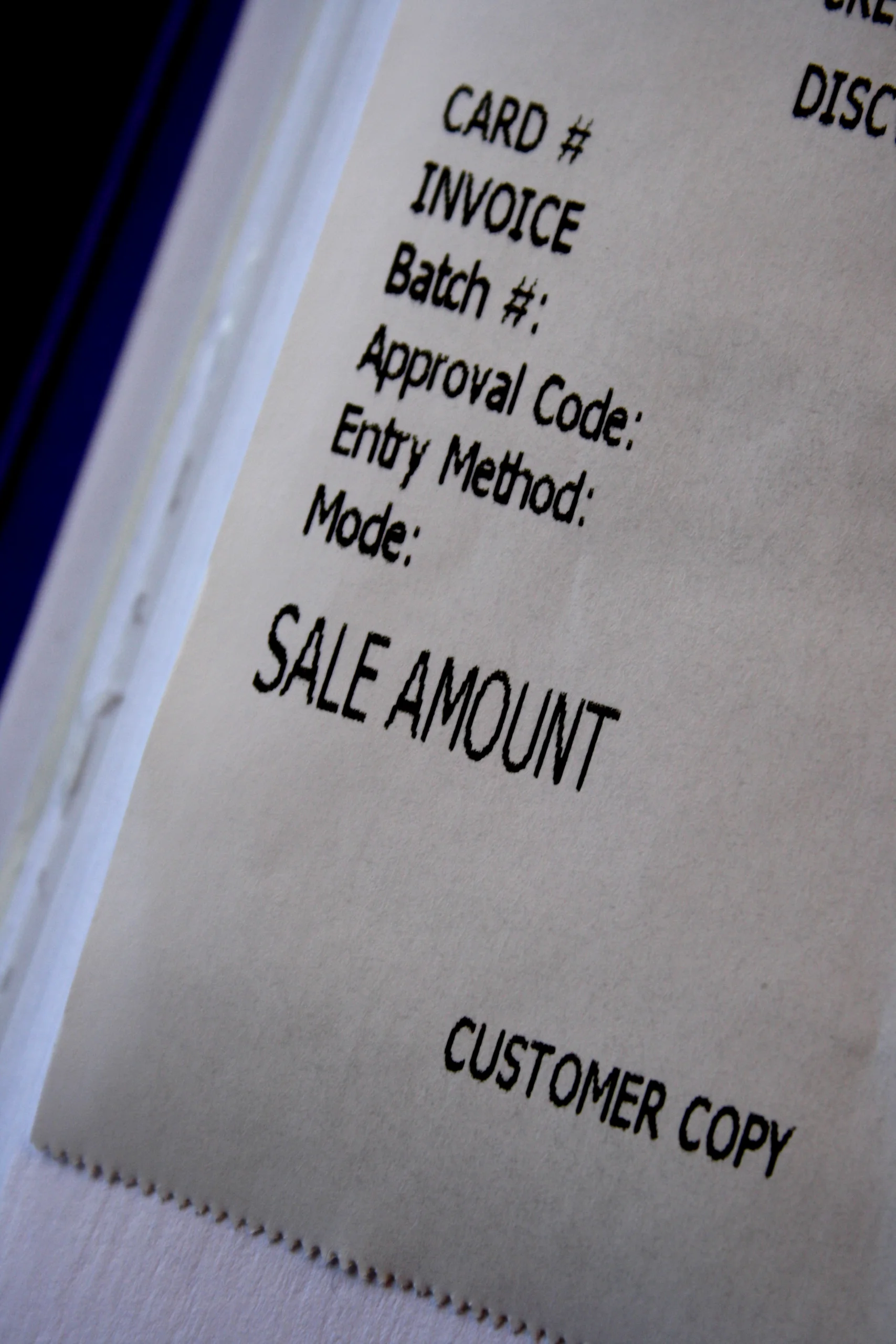 Close-up of a paper credit-card receipt showing blank fields for a card number, invoice and sale amount