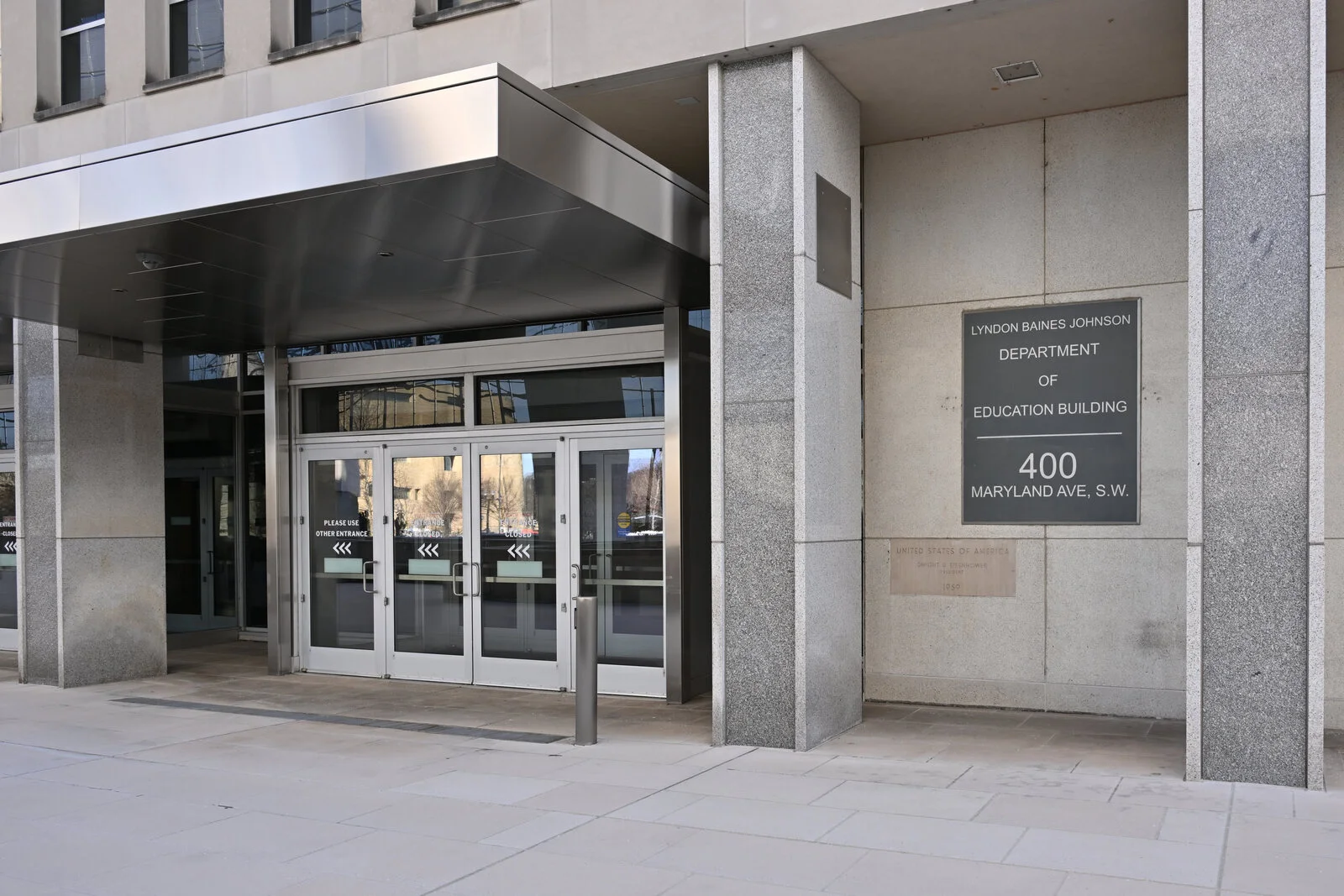 Glass doors under a steel canopy beside a sign reading Lyndon Baines Johnson Department of Education Building, 400 Maryland Ave. S.W.