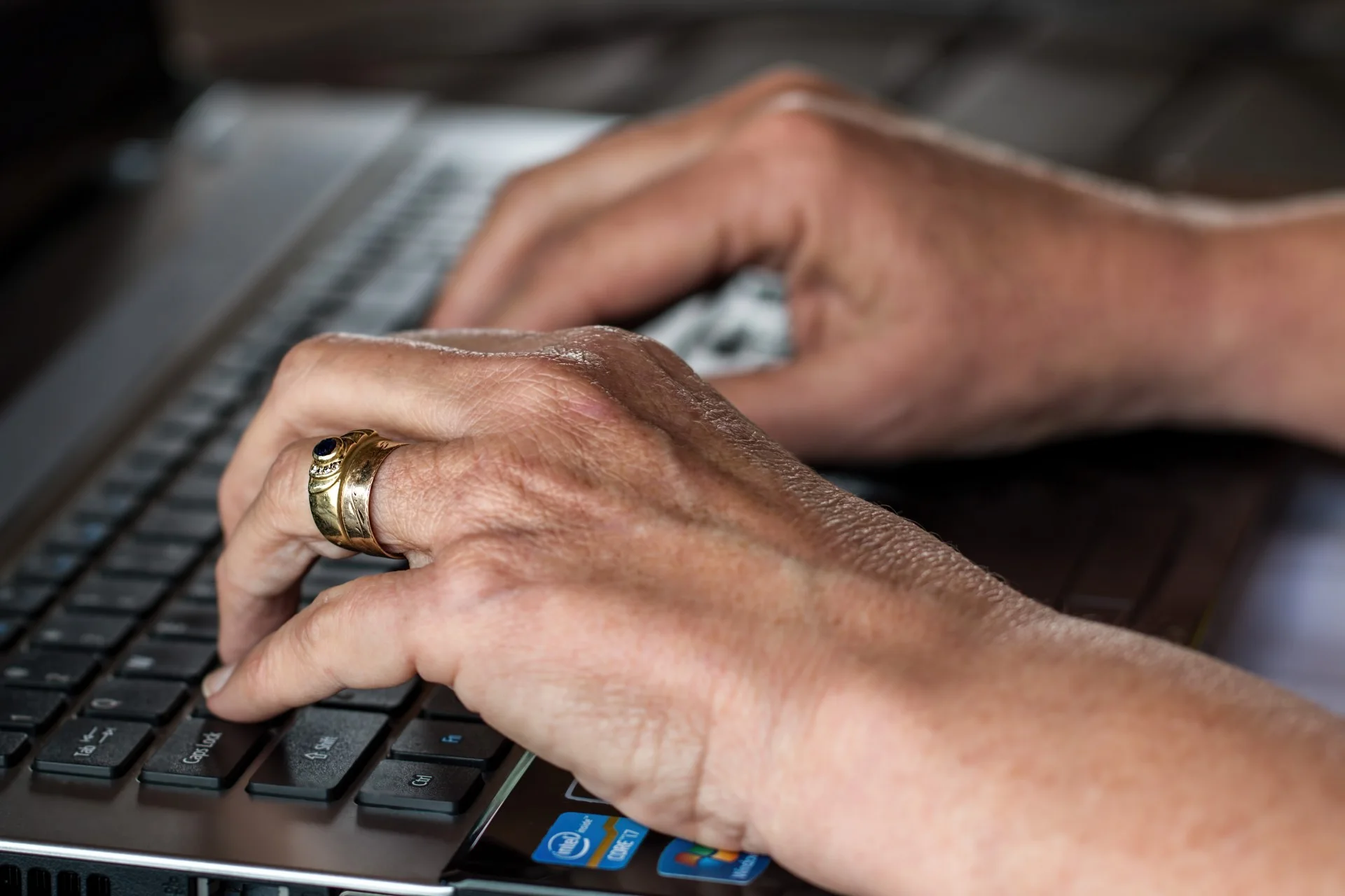 Hands typing on a laptop keyboard
