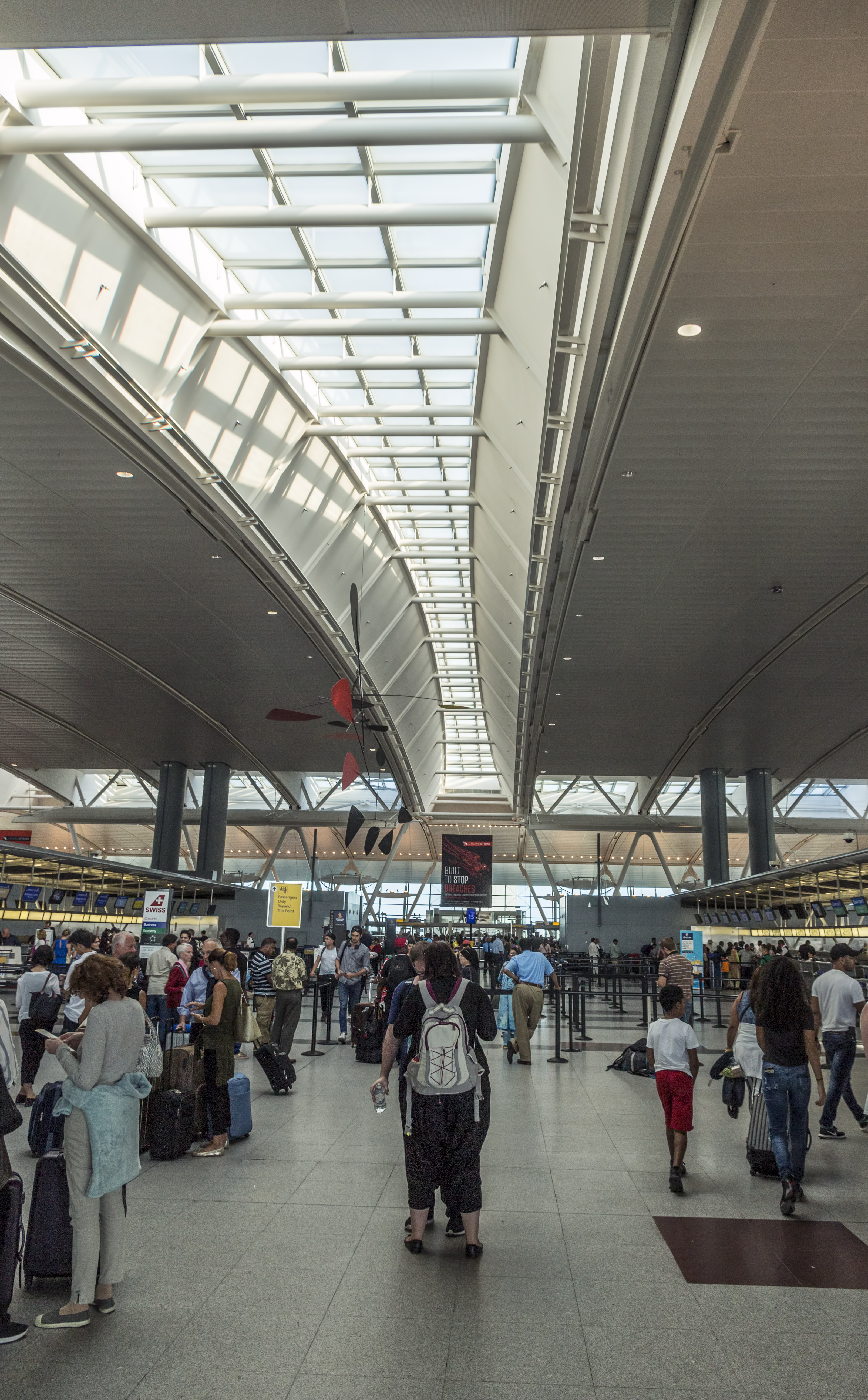 Travelers with luggage beneath the skylight in JFK Terminal 4 in 2016.