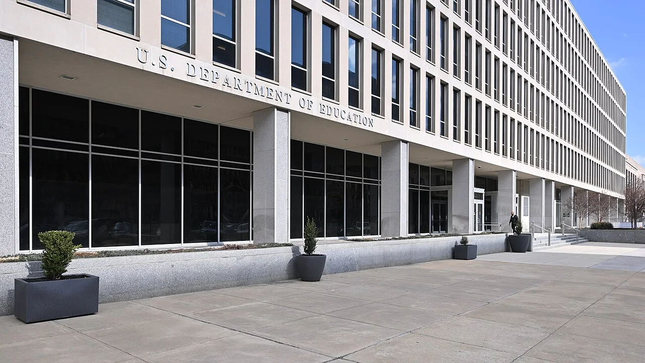 The entrance of the U.S. Department of Education headquarters in Washington, with the department name above a glass facade