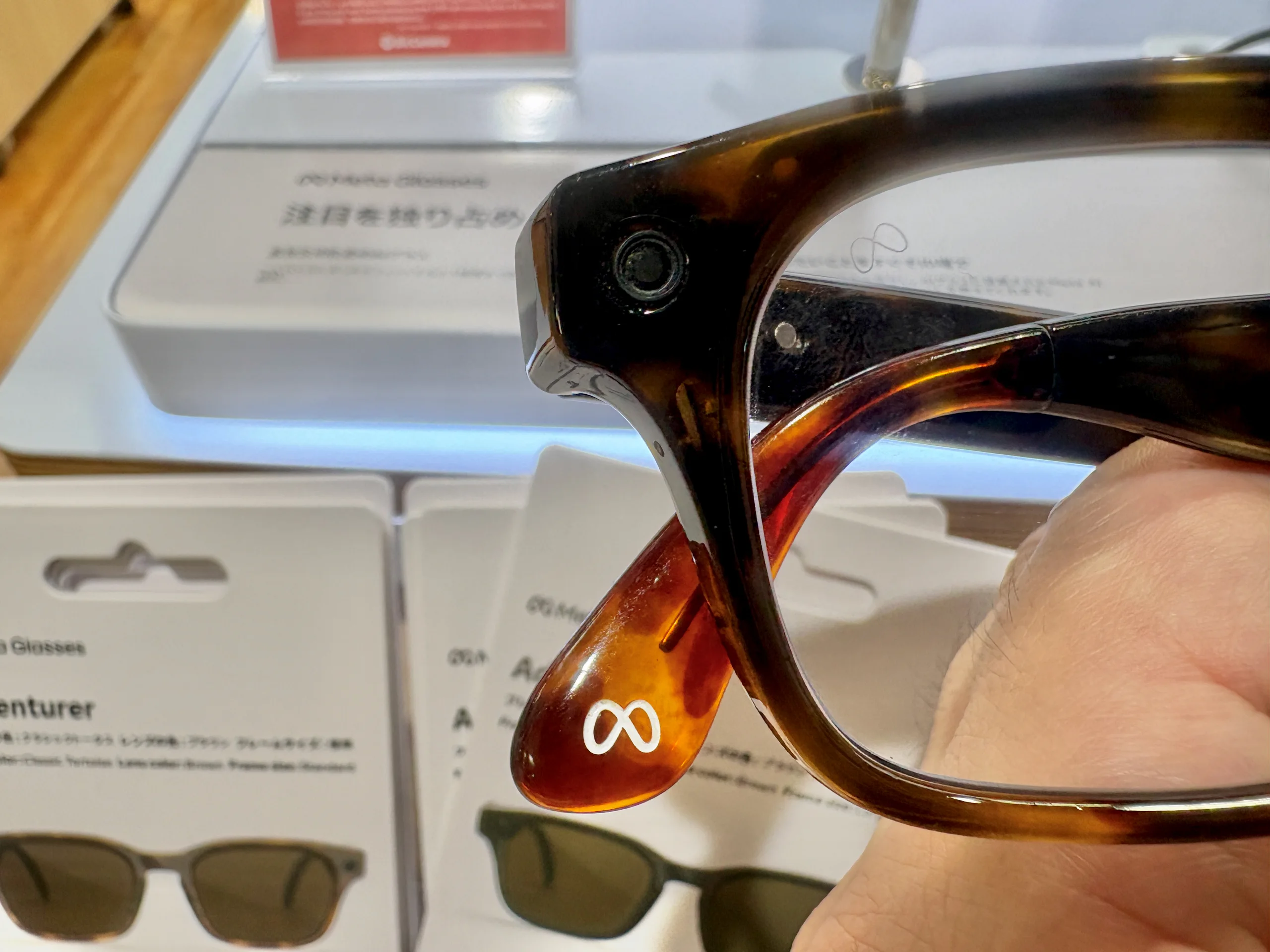 Close view of a camera lens built into a tortoiseshell Meta glasses frame