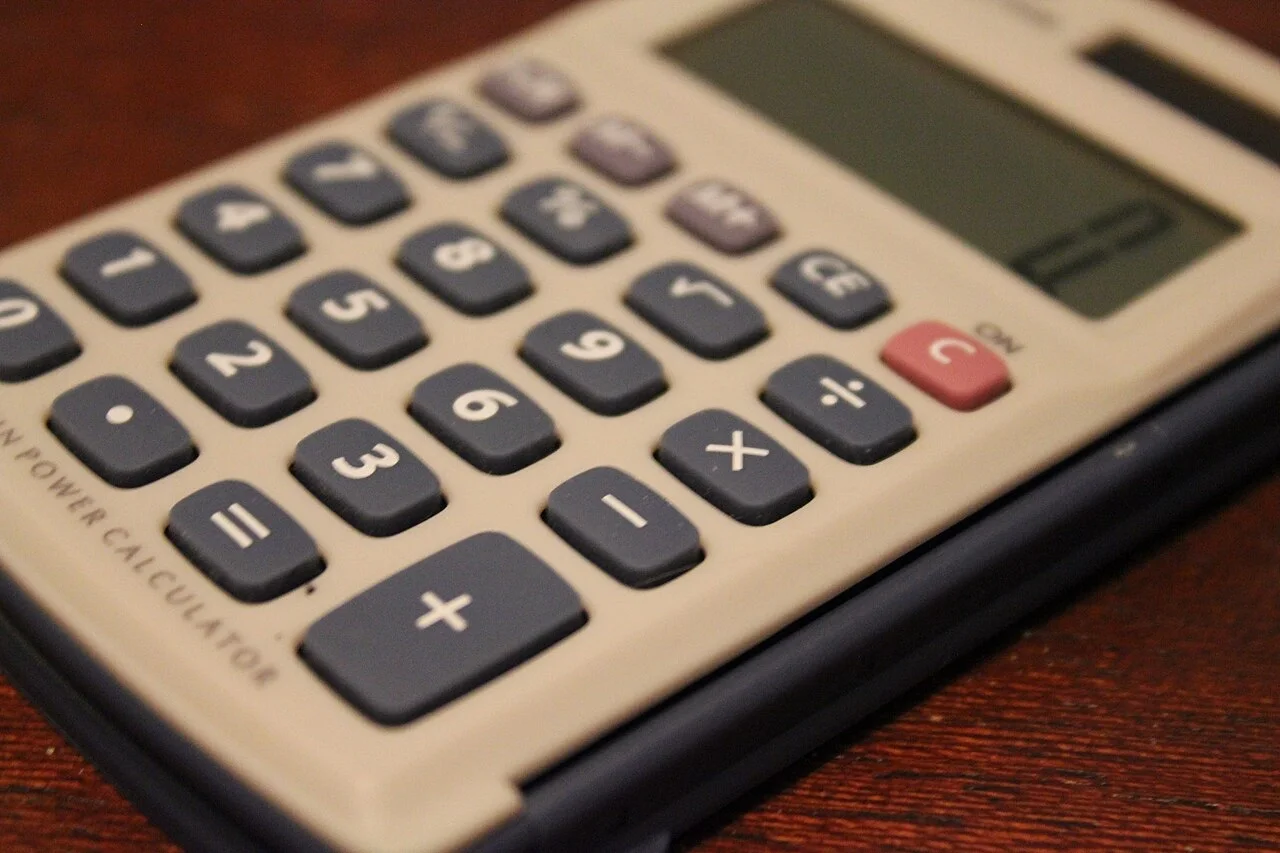 Close-up of a four-function calculator on a wooden surface