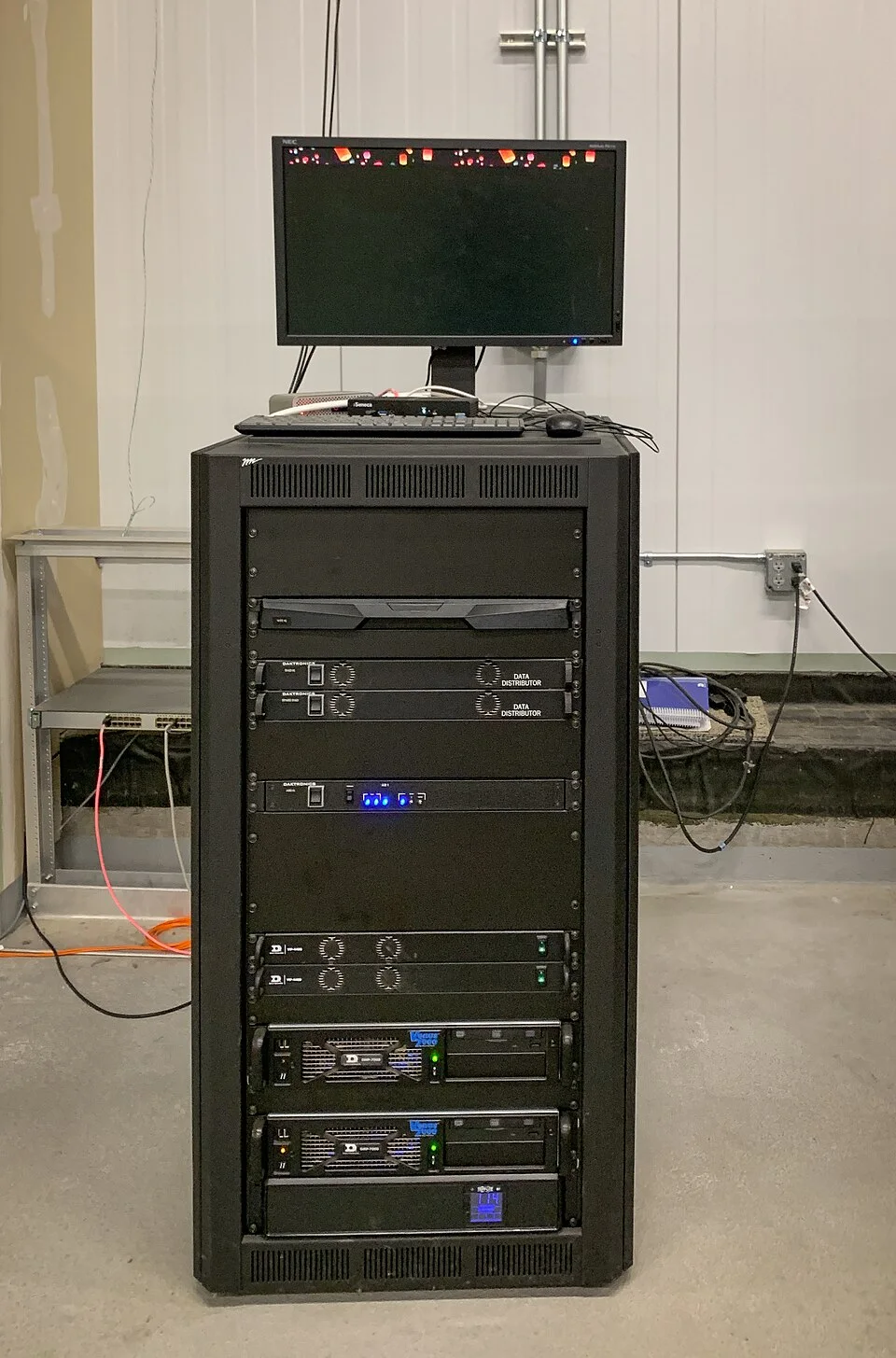 A server rack with a monitor and keyboard above the equipment.